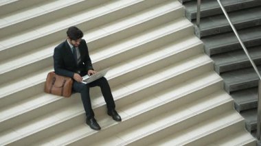 Üst düzey bir iş adamı merdivenlerde otururken başarılı bir projeyi kutluyor. Proje yöneticisi yeni bir pozisyon alıyor, terfi alıyor, arkadaşlarını ararken dizüstü bilgisayar kullanarak satışları artıyor. Sevinçli..