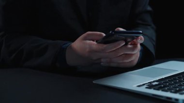 Modern iletişim teknolojisini ve modern çalışma alanındaki kullanıcı etkileşimini gösteren, bir dizüstü bilgisayarın yanında sohbet yapay zeka arayüzü gösteren şık bir akıllı telefon. Dörtgen