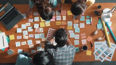 Bir grup yaratıcı ekip fikir ararken ve planlarken yönetici de elinde yapışkan notlar tutarken ve başlangıç projesi hakkında liderlere pazarlama stratejisi sunarken. Beyin fırtınası planının en iyi görüntüsü. Sempozyum.