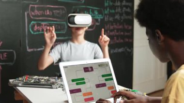 Afrikalı erkek programlama sistemi, beyaz bir kız karatahtanın başında mühendislik kodlarıyla otururken metaverse 'e giriyor. Liseli kız STEM teknolojisinde VR ya da kulaklık takıyor. Öğretim