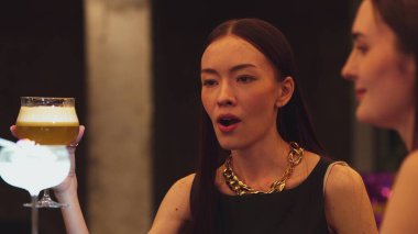 Lüks tezgah barında votka kokteyli içen güzel bir kadının tadını çıkarın. Arkadaşlarla kadeh kaldırın. Gece hayatı lüksünün özünü yakalayın. Vinosity.