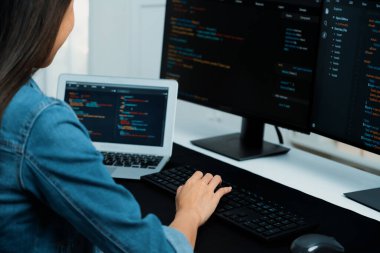 İnternet sitesi uygulamasının kodlama verileriyle birlikte online bilgi yazarak kot gömlek giyen genç Asyalı geliştirici. Güvenlik analizi ile çevrili iki ekran. Taktik.