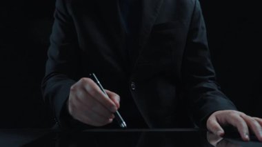 Sanal güvenlik ve veri korumanın önemini vurgulayan takım elbiseli bir profesyonel, bir tablet üzerindeki dijital kilit ve güvenlik simgelerinin holografik temsili ile etkileşim halindedir. Dörtgen