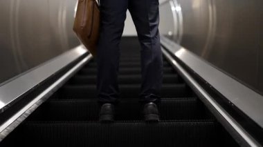 Yürüyen merdivenlerde duran zeki profesyonel iş adamının bacağı. Yetenekli proje yöneticisi terfi alıyor, yeteneğini arttırıyor, yükseltiyor, yeni bir pozisyon alıyor. Merkez. Bacağa odaklan. Sevinçli..