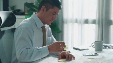 Profesyonel mühendis, türbin motoru veya jet motoru tasarımı ve çeşitli metal teçhizat dağılımı ile toplantı masasında yeşil ekranlı tablet üzerinde çalışırken telefona bakıyor. Hizalama.