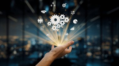 A hand releases vibrant gears and icons symbolizing innovation and technology, showcasing the essence of collaboration and creative solutions in a corporate setting. Auvana