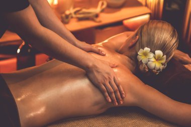 Beyaz kadın müşteri stres önleyici spa masajının keyfini çıkarıyor ve lüks otel ya da otelde sıcak mum ışığında güzellik teniyle eğleniyor. Sessiz.