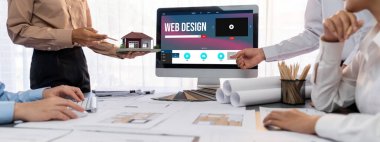 İç mimar tasarımcı grubu, daha kesin tasarım için planlar ve dizüstü bilgisayar ekran mimari yazılımı üzerinde birlikte tartışıyorlar. Modern ev tasarımı ve yenileme. İçgörü