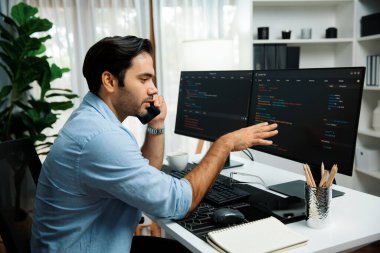 Akıllı IT geliştirici yöneticisi, bilgisayar ekranındaki yazılım kodlama sistemindeki sorunu çözen iş arkadaşına seslenerek modern ofiste uygulama programı güncellemesi yapıyor. Tahmin et..