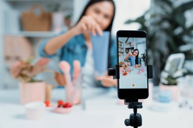 Genç ve güzel Asyalı bir kızın nemlendirici vücut kremi ürününü inceleyerek sosyal medyada koluyla en çok satanlar listesine giren canlı bir cilt testi yaptığı seçmeli bir odak telefonu. Taktik.