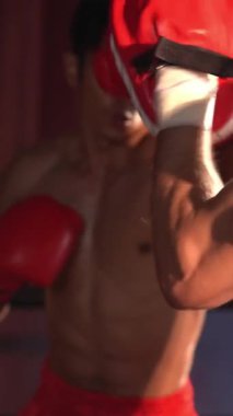 Asyalı ve Kafkasyalı Muay Thai boksörü boks antrenmanında boks antrenmanında boks antrenörüne yumruk atma, Muay Thai boks tekniği ve becerilerini sergileme. Impetus