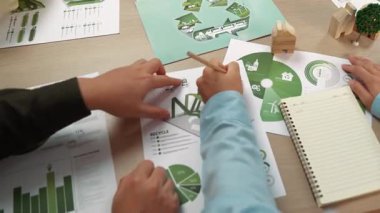 Mükemmel iş adamları, yeşil enerji grafiği kullanımı olan karmaşık bir masada eko ev projesini tartışıyor alternatif enerjiyi seçiyor ya da analiz ediyor, karbonu azaltıp dünyayı kurtarıyor. Eline odaklan. Tanımlama.