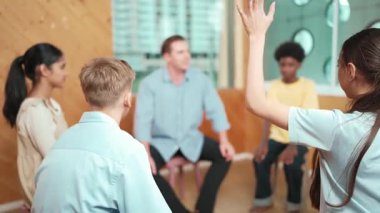 Grup terapisi sırasında soru sormak için elini kaldıran akıllı kız. Lise öğrencisi, grup toplantıları arasında soru sormak, oy vermek, gönüllü olmak, soru sormak ve cevaplamak için el kaldırdı.