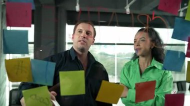 Yetenekli işadamı pazarlama fikrini cam duvardaki proje yöneticisine sundu. Yönetici projeyi yatırımcıya açıklıyor. Zeki iş adamları birlikte çalışıyor, beyin fırtınası yapıyorlar. Yönlendirici.