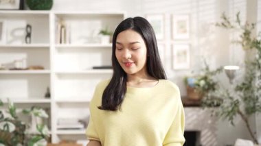 Anahtarı elinde tutan genç girişimci, merkez büroda dikilirken. Küçük işletmeleri yönetmek ya da başlamak için anahtarı taşırken kameraya özgüvenle bakan mutlu kadın satıcı. Myrmidon.