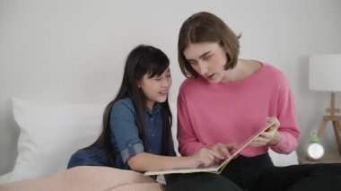 Beyaz bir anne, tatlı kızının dinlediği hikayeleri okuyor. Asyalı kız yatmadan önce hikâyeyi anlatırken işaret etti. Birlikte vakit geçirirken mutlu bir aile yatakta oturuyor. Pedagoji.