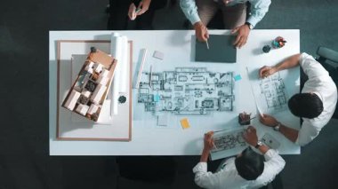 İnşaatı analiz etmek için dizüstü bilgisayar kullanan proje yöneticisinin yukarıdan aşağıya hava görüntüsü. Beyin fırtınası yaparken mühendis planlama ve yazma havadan görüntüsü. Hizalama.