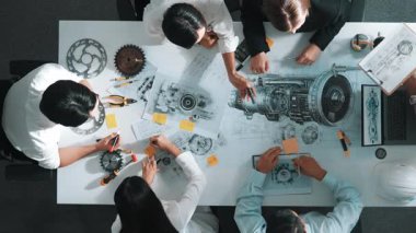 Mühendisin, toplantı masasındaki türbin motorunu ekipmanla gösteren üst düzey görüntüsü. Profesyonel proje yöneticisinin elektronik jeneratör sistemi hakkında konuştuğu ve tartıştığı hava görüntüsü. Hizalama.