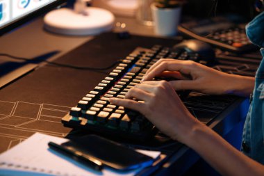 Genç ve güzel Asyalı yaratıcı bir kadının klavyeye yazıp bilgisayar üzerinden yeni proje yaratıcısı sosyal medyayı araştırması ve neon modern ofiste strateji pazarı kurması. Taktik.