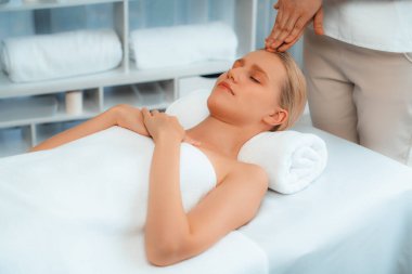 Kafkasyalı kadın stres önleyici kafa masajından ve lüks tatil beldesi ya da otel spa salonundaki modern ışık ortamında yüz güzelliği eğlencelerini şımartmaktan hoşlanıyor. Sessiz.