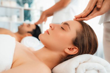 Kafkasyalı çift stres önleyici kafa masajının keyfini çıkarıyor ve lüks otellerde ya da otel spa salonlarında gündüz kaplıcalarında yüz güzelliği eğlencelerini şımartıyor. Sessiz.