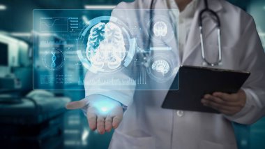 Doktorun tableti tutmasına ve laboratuvarda bulanık bir geçmişi olan beyin hologramını tutmasına yakın çekim. Beyin ameliyatına hazırlanan bir tıp çalışanı beyin araştırması yapıyor. İyileştirici.