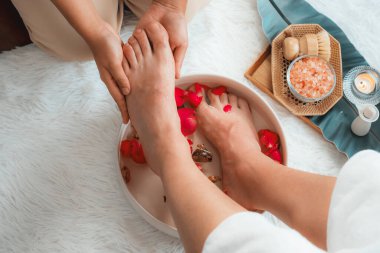 Kadınlar lüks spa salonlarında keyifli ayak masajlarına devam ederken, masör de hafif gün ışığı atmosferinde refleksoloji terapisi veya otel ayak spa 'sında. Sessiz.
