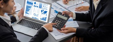 İş zekası ve veri analizi kavramı. Analizci ekibi laptop ekranında finansal veri analizi üzerinde çalışıyor. Etkili iş stratejik planlama için pazarlama göstergesi olarak. İçgörü