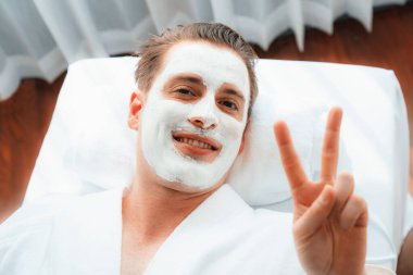 Kaplıca salonunun sakin atmosferi, insan müşterisi modern gün ışığında lüks yüz kremi masajıyla kendini yenileme zevkine kapılıyor. Yüz bakımı ve güzellik konsepti. Sessiz.