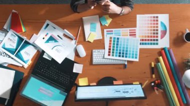 Top down aerial view of skilled interior design graphic talking to manager by using phone. Project manager working while using telephone and listen to team and discuss building design idea. Symposium.