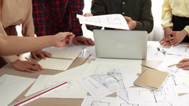 Akıllı mimar ve güvenlik mühendisi, mimari belge, ölçüm araçları ve ahşap blokların modern ofiste etrafa saçıldığı masa planlarını tartışıyor. - Yakın çekim. Tanımlama.