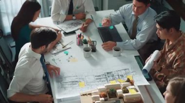Proje planıyla masaya otururken bir grup farklı takım planlama stratejisi. Zeki iş adamlarının beyin fırtınası ve ev yapımı için birlikte çalıştıklarının en üst düzey görüntüsü. Hizalama.