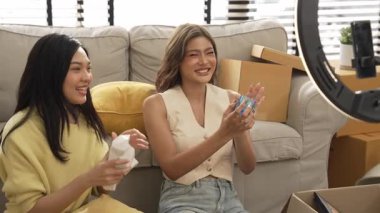 Çekici satıcı çevrimiçi platform kullanarak canlı yayın yaparken ürünü incelemek ve satmak için birlikte çalışıyor. Zeki Asyalı girişimci soruları cevaplarken ürün gösteriyor. Medya. Myrmidon.