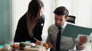 Profesyonel mimar mühendis ekibinin yapış yapış notlar yazıp toplantı masasına not bırakırken iç mimar tasarımcılarının dış tasarım hakkında konuştuklarını ve tartıştıklarını görüyoruz. Hizalama.