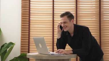 Mutlu iş adamı ya da satıcı online iş yapıyor, uzaktan kumandayla çalışıyor ve evdeki satışlar için telefon görüşmesi yapıyor. Telesyaller ve iletişim ile modern iş. Düzenle