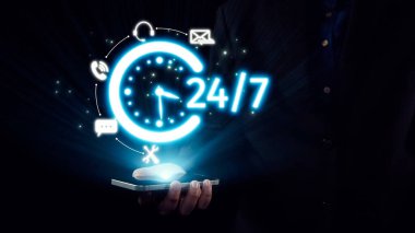 Profesyonel bir birey, bir saat simgesi ve çeşitli iletişim sembolleri tarafından temsil edilen parlak bir 24 saatlik servis konseptini karanlık bir arkaplana karşı sergileyen bir akıllı telefon bulundurur. Dörtgen