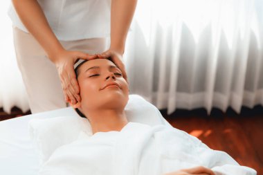 Kafkasyalı kadın stres önleyici kafa masajından ve lüks tatil beldesi ya da otel spa salonundaki modern ışık ortamında yüz güzelliği eğlencelerini şımartmaktan hoşlanıyor. Sessiz.