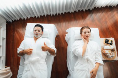 Kaplıca salonunun sakin, modern gündüz atmosferi, birkaç müşteri yüz maskesi takarak kendini yenilemeye çalışıyor. Yüz bakımı ve güzellik kozmetolojisi prosedürü. Sessiz.