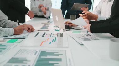 Çeşitli bir iş ekibi, profesyonel bir toplantı sırasında mali tablolar ve verileri analiz ederek, iletişim ve stratejiyi teşvik ederek çağdaş bir ofis ortamında işbirliği yapıyor. SACTR