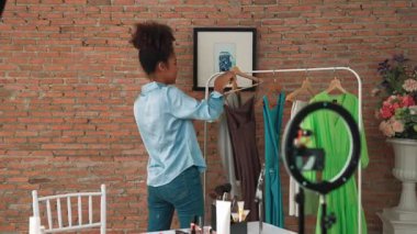 Kadın nüfuzlu kişi canlı yayında video görüntülerini çekiyor. Kıyafetler sosyal medya ya da blog için çok önemli. Stüdyo ışıklandırmalı mutlu genç kız çevrimiçi pazarlama oturumu yayını için..