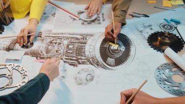Mühendislerin uçak motorunun planları üzerinde çalıştıklarını gösteren detaylı bir işbirliği sahnesi. Çevrede takım çalışması ve yenilikleri gösteren araçlar ve eskizler sergileniyor. SACTR