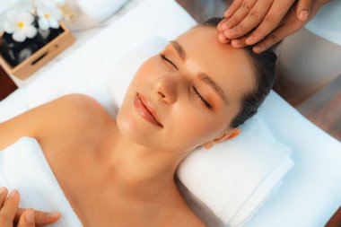 Kafkasyalı kadın stres önleyici kafa masajından ve lüks tatil beldesi ya da otel spa salonundaki modern ışık ortamında yüz güzelliği eğlencelerini şımartmaktan hoşlanıyor. Sessiz.