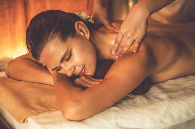 Beyaz kadın müşteri stres önleyici spa masajının keyfini çıkarıyor ve lüks otel ya da otelde sıcak mum ışığında güzellik teniyle eğleniyor. Sessiz.