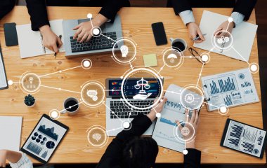 Veri görselleştirmeleri ve dijital simgelerle çevrili bir iş toplantısında yer alan bir grup profesyonel, işbirliğini teşvik etti. Dostluk