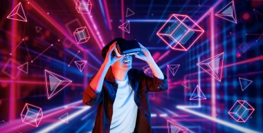 Afrikalı adam, VR kulaklık takıp parlak mavi ve pembe geometrik şekillerde dururken metaevreni keşfetmek için heyecanlanıyor. Oyuncu artırılmış gerçeklik gözlüğü kullanırken oyun oynuyor. Yaratıcılık.