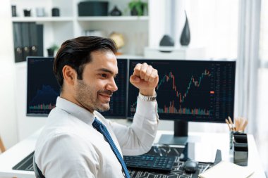 Akıllı tüccar işadamı, modern merkez ofisindeki araştırma pazarında en yüksek kârlı finansal teknolojiye yatırım yaparak bilgisayar üzerinde iki dinamik borsa yatırım ekranını analiz ediyor. Tahmin et..