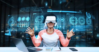 Masada ödev yaparken yapay zeka kullanarak metaevreleri birbirine bağlayan dizüstü bilgisayar ve artırılmış gözlük kullanan bir kız. Öğrenci holograma bakıyor ve bulanık ofiste oturuyor. Yaratıcılık.