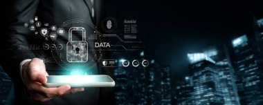 Profesyonel bir adam takım elbise içinde elinde akıllı bir telefonla şehrin siluet arkaplanına karşı kilit ve veri simgeleriyle fütürist bir siber güvenlik arayüzü sergiliyor. XDMCP