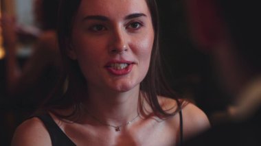 Odaklanmış güzel, çekici bir kadının portresi yatay manzaralı arkadaşlarla sohbet ediyor. Gece kulübünde sosyetik atmosferde doğal yüz güzelliği yakalamak. Vinosity.