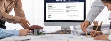 İç mimar tasarımcı grubu, daha kesin tasarım için planlar ve dizüstü bilgisayar ekran mimari yazılımı üzerinde birlikte tartışıyorlar. Modern ev tasarımı ve yenileme. İçgörü